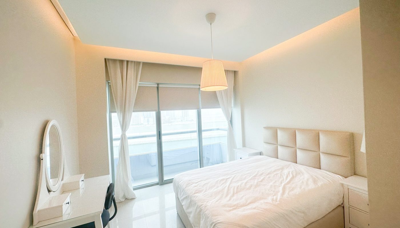 A luxury bedroom with a bed and a desk, offering a stunning sea view.