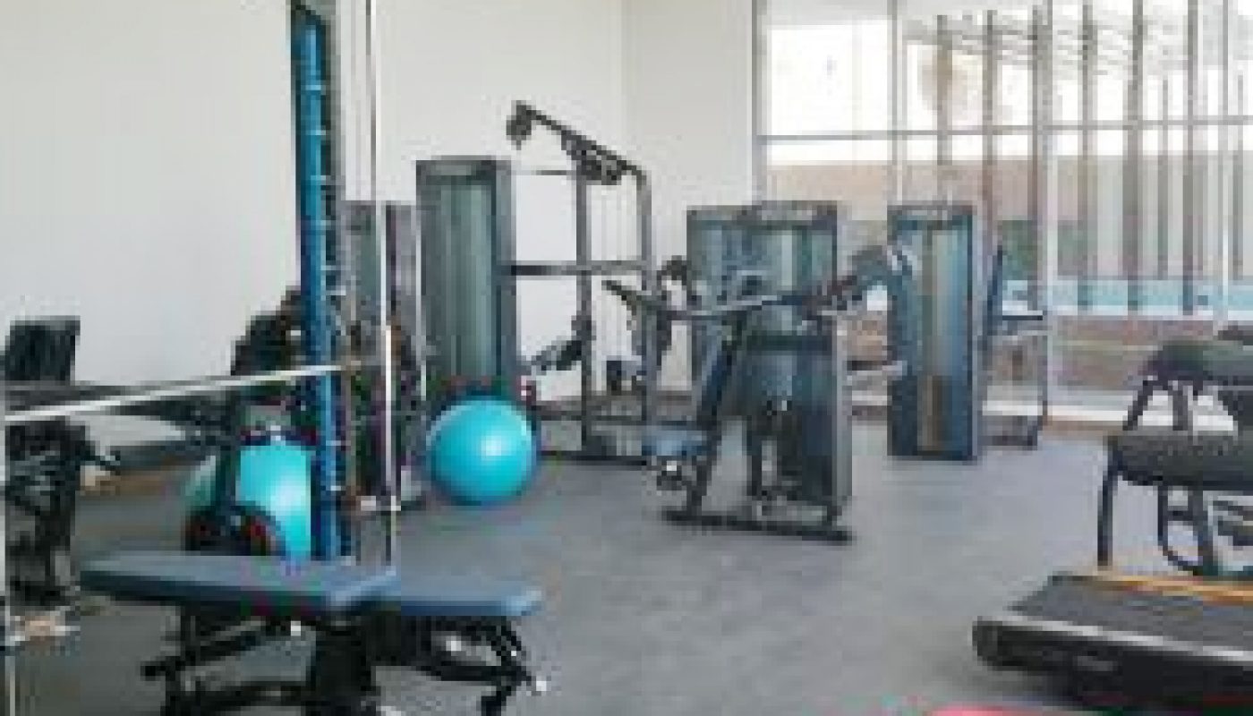 A luxury studio for rent in Busaiteen with a gym room equipped with a lot of equipment.