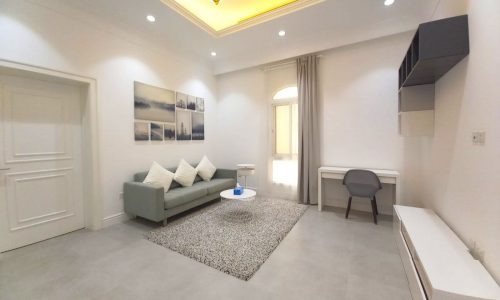 Extraordinary living room with white couch and white walls in a brand new villa for rent in Janabiyah.