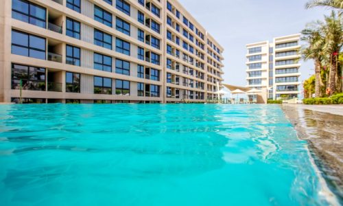 Stunning swimming pool in front of a luxury apartment building.