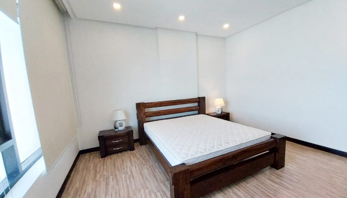 A luxury apartment with two bedrooms, featuring wooden floors and a wooden bed.