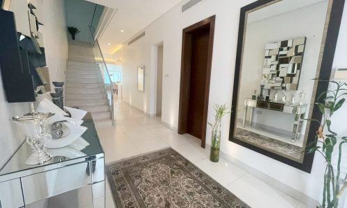 A modern home interior featuring an elegant hallway with a staircase, decorative mirror, Auto Draft furnishings.