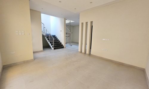 Empty room under construction with unfinished walls, bare floors, and a staircase leading to an upper level, categorized as "Auto Draft.