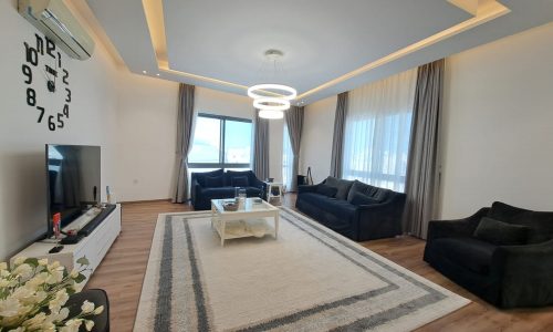 A luxurious apartment in Al Janabiya for sale, featuring a living room with a large flat screen TV.