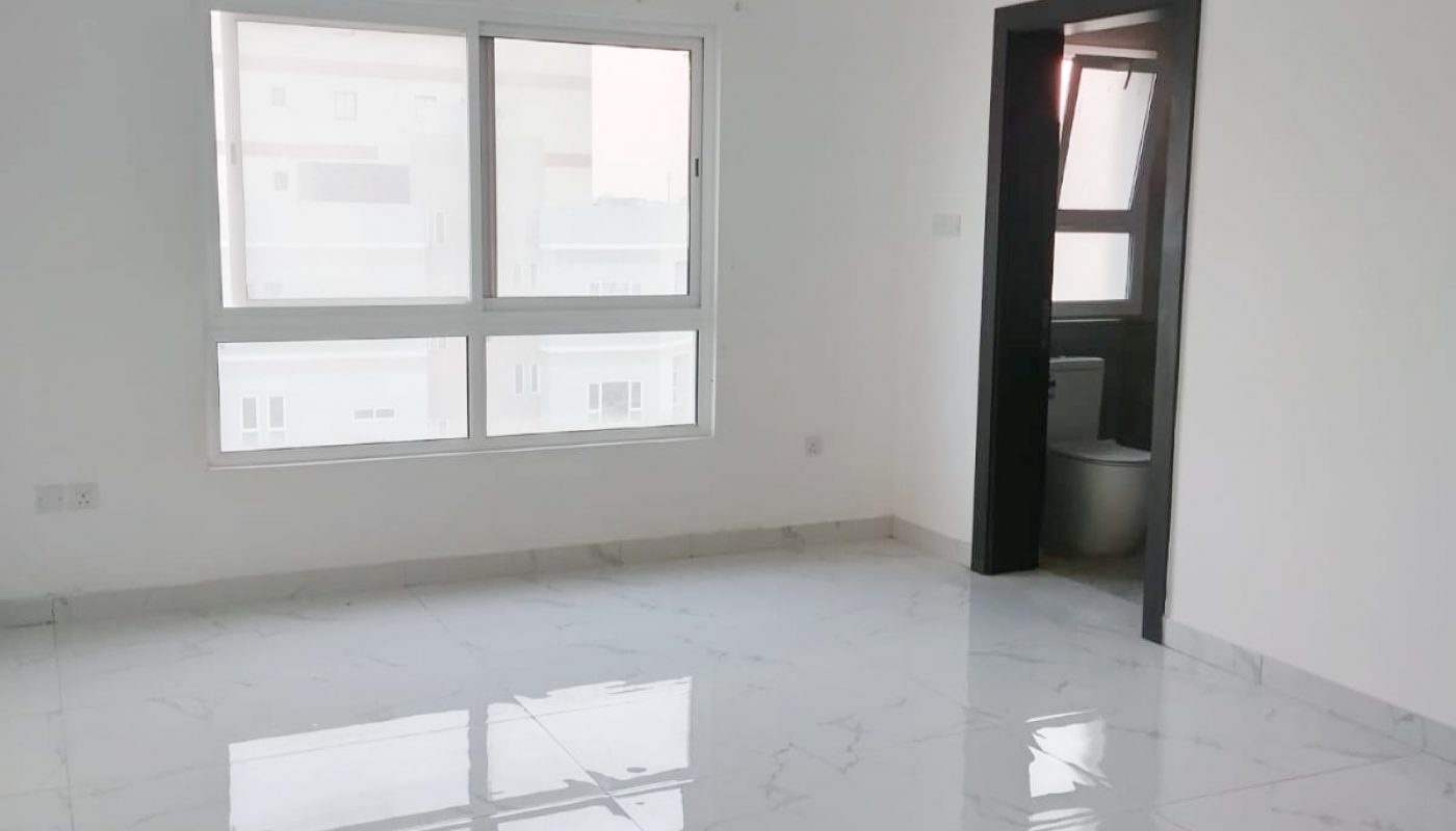 A white tiled room with a window and a door.