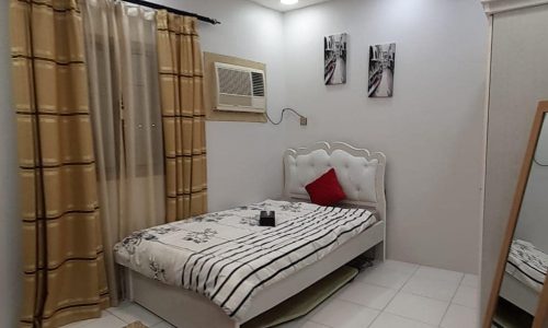 Apartment for sale in Samaheej with a bed and a mirror in the bedroom.