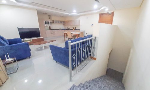 3BR Apartment for Rent in Amwaj featuring a living room with a blue couch and a tv.