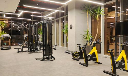 A spacious gym room with yellow and black equipment.