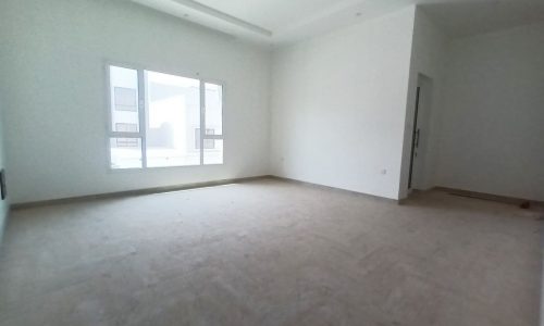 An empty room with white walls and wooden floors.