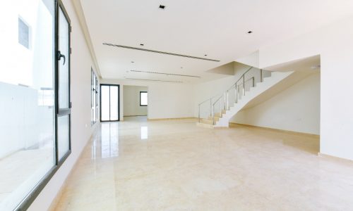 A modern house with stairs and white walls in Hamala featuring 2 gardens.