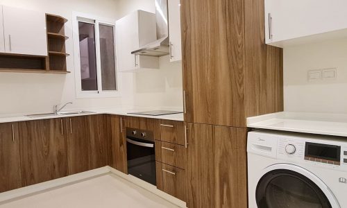 A spacious apartment for rent in a new building, featuring a kitchen with a washer and dryer.