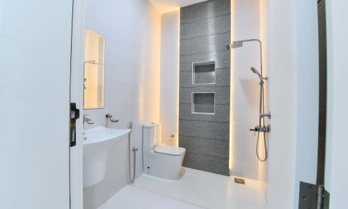 A luxurious bathroom in a modern apartment, complete with a toilet, sink, and shower.