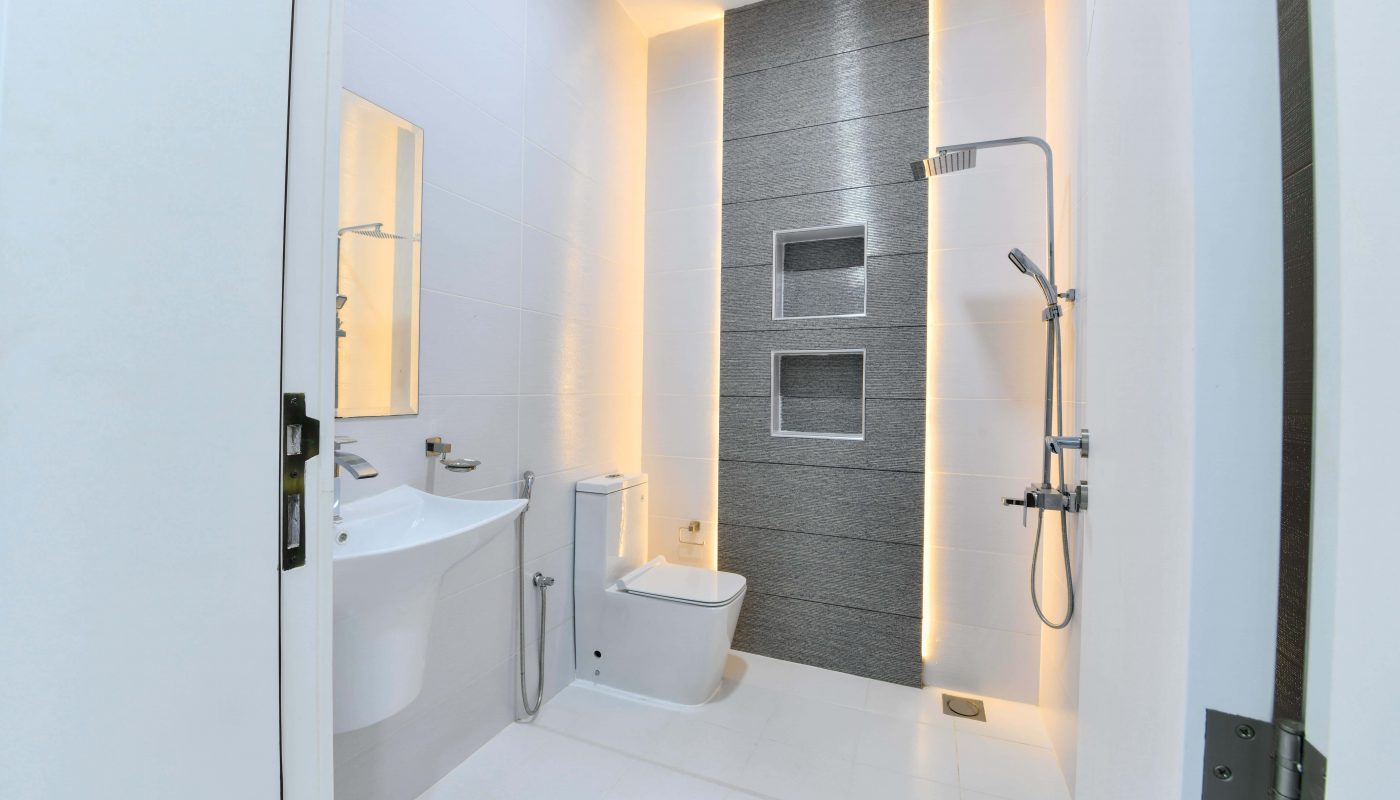 A luxurious bathroom in a modern apartment, complete with a toilet, sink, and shower.