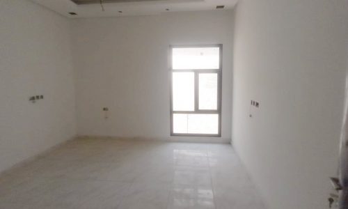 An empty room with white walls and a door available for sale.