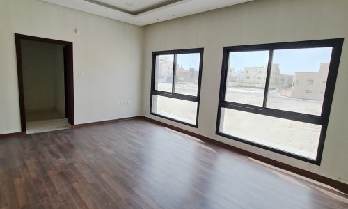 Brand New villa for sale in Barbar: An empty room with wooden floors and large windows.