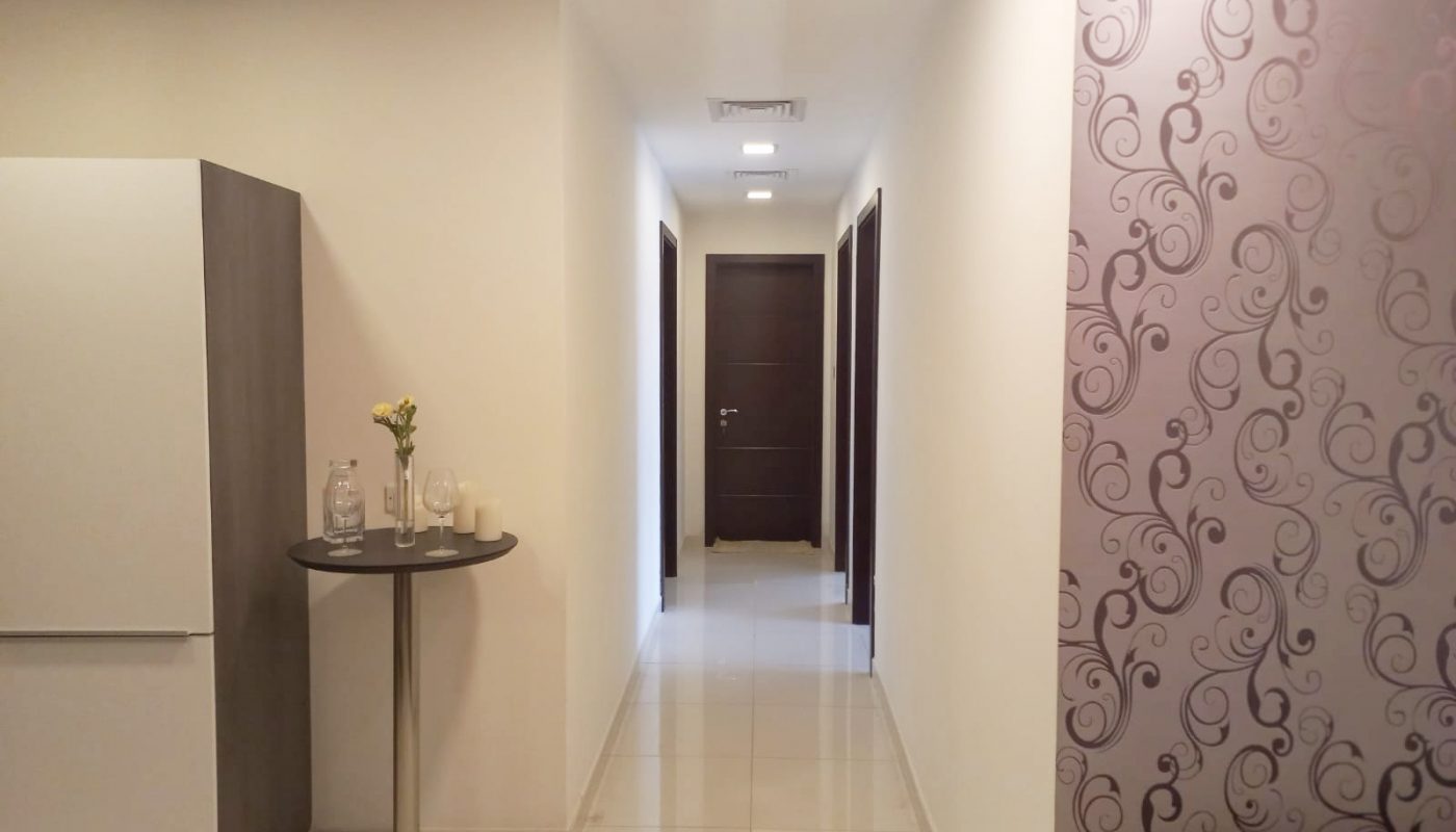 A luxury apartment for sale in Janabiyah with a purple couch and white walls.