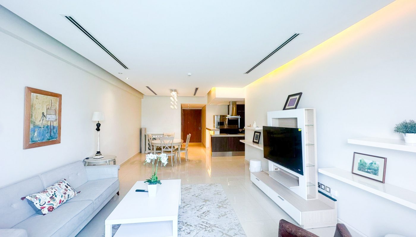 A luxury living room in a Sea View Apartment on Reef Island with white furniture and a TV.