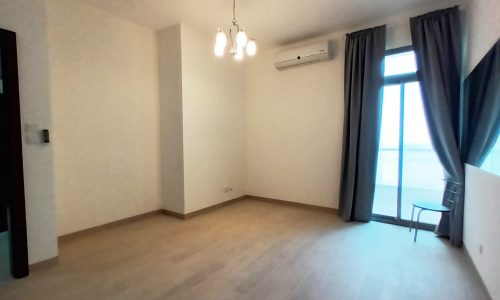 Spacious empty room with wooden floors and a ceiling fan.