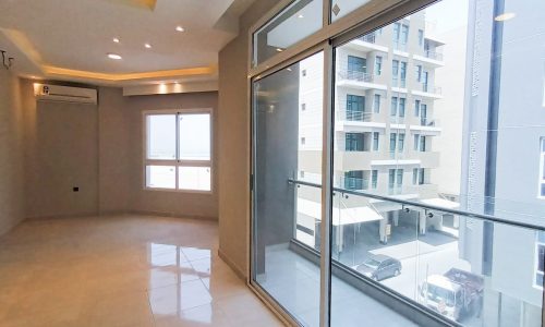 A brand new apartment with sliding glass doors and a view of the city.