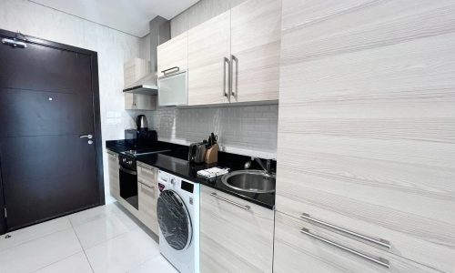 A small kitchen with a washer and dryer in an Amazing Building.