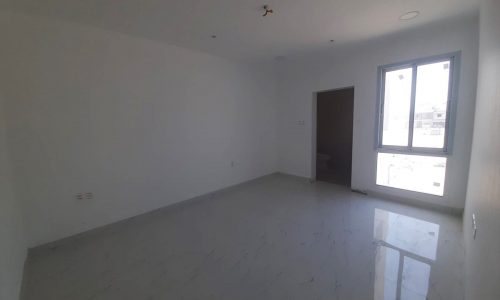 An empty brand new room with white walls and a window.