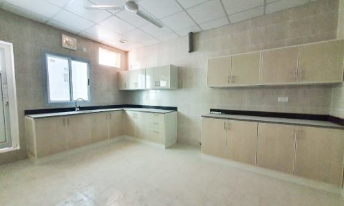 A luxury apartment in Riffa for sale with white cabinets and a ceiling fan.