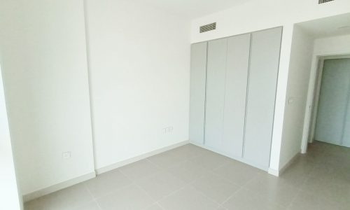 An empty room with white walls and doors in a stunning luxury apartment.