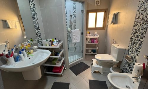 A spacious villa for sale in Saar with a beautiful bathroom featuring a sink, toilet, and shower.