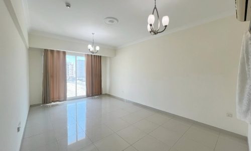 A room with a tile floor, a chandelier, and some furnished items.