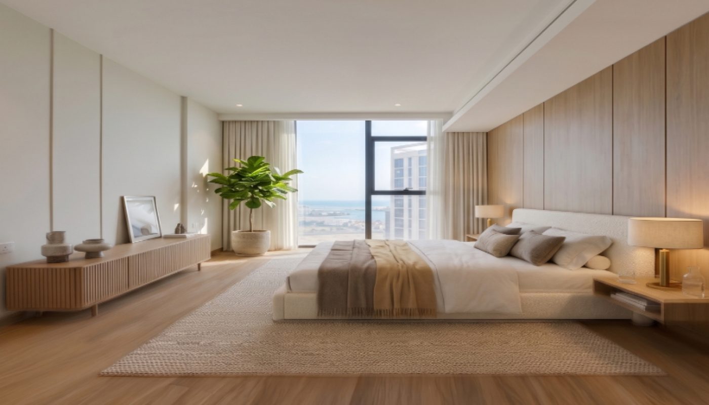 Modern bedroom with wooden flooring, a large bed, neutral decor, a sideboard with framed art, a potted plant, and a floor-to-ceiling window with city and water views.