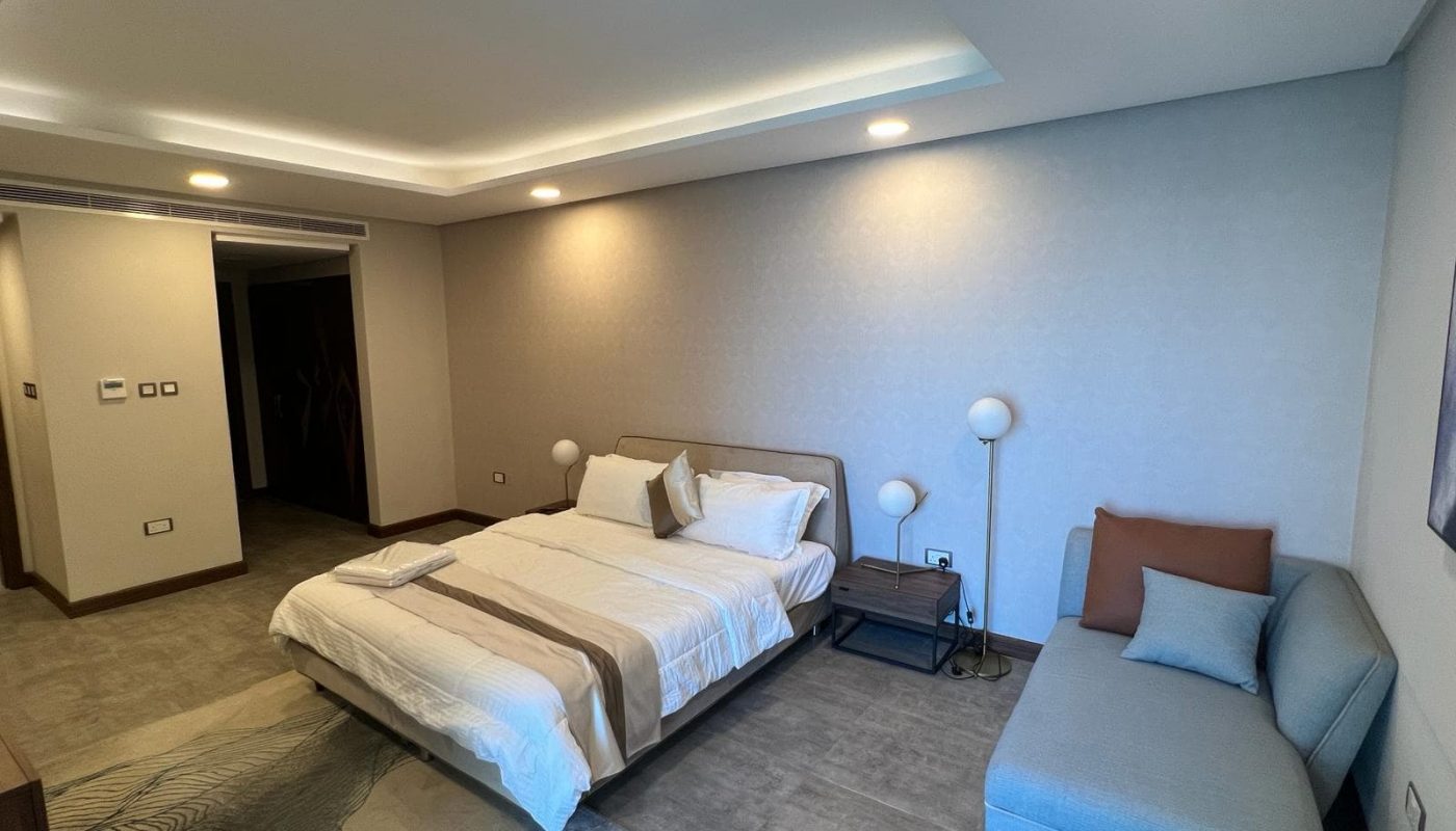 A fully furnished bedroom with a bed and a couch.