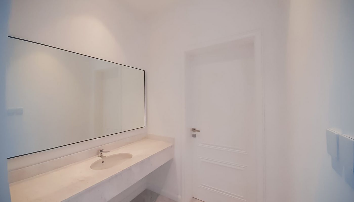 An Eye-Catching white bathroom with a mirror and sink.