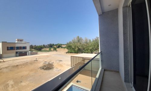 A balcony with an amazing view of an empty lot.