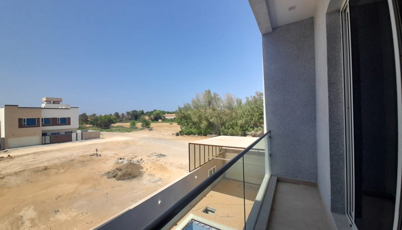 A balcony with an amazing view of an empty lot.