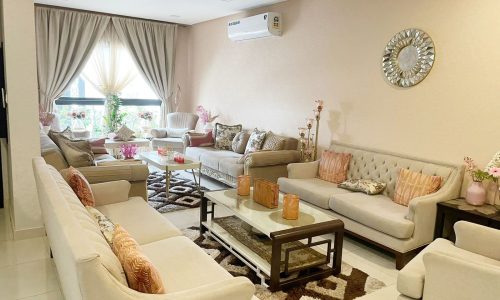 A spacious living room in a luxury villa with couches and a coffee table.