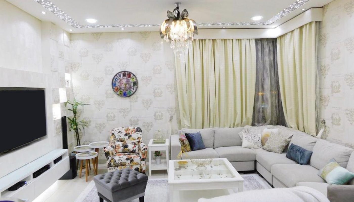 Luxury living room with white furniture and a tv.