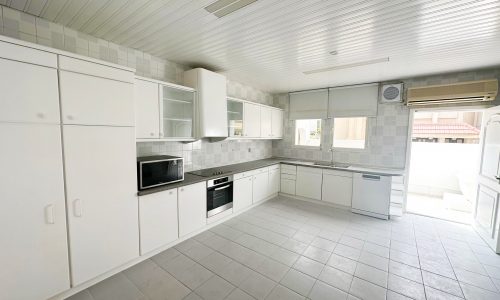 A white kitchen in a 3BR Mahooz Villa for Rent with a stove and oven.