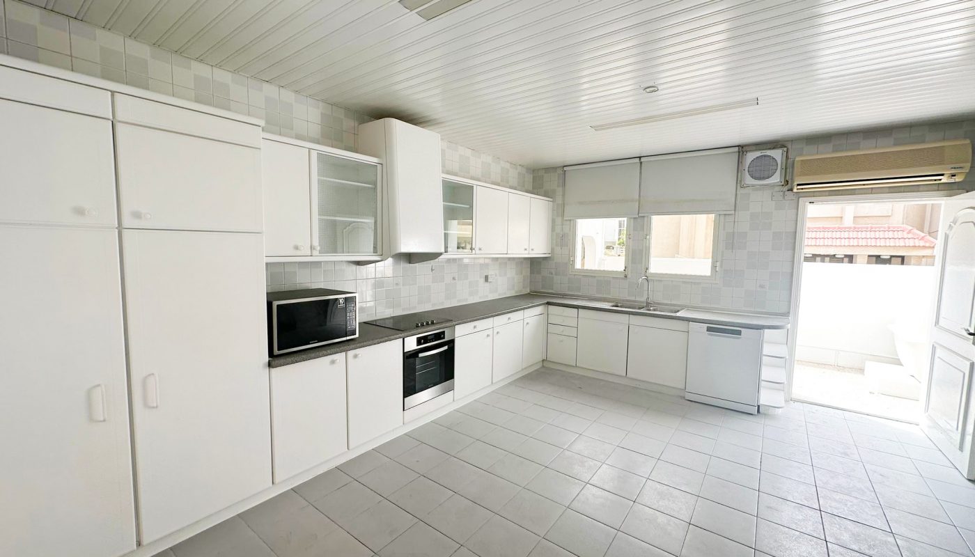 A white kitchen in a 3BR Mahooz Villa for Rent with a stove and oven.