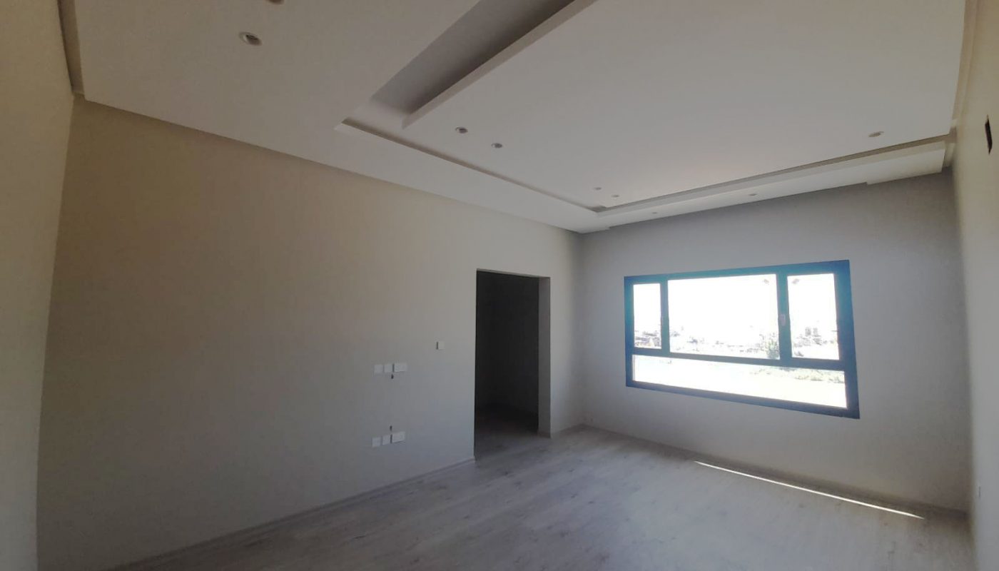 Stunning empty room with wooden floors and a window.