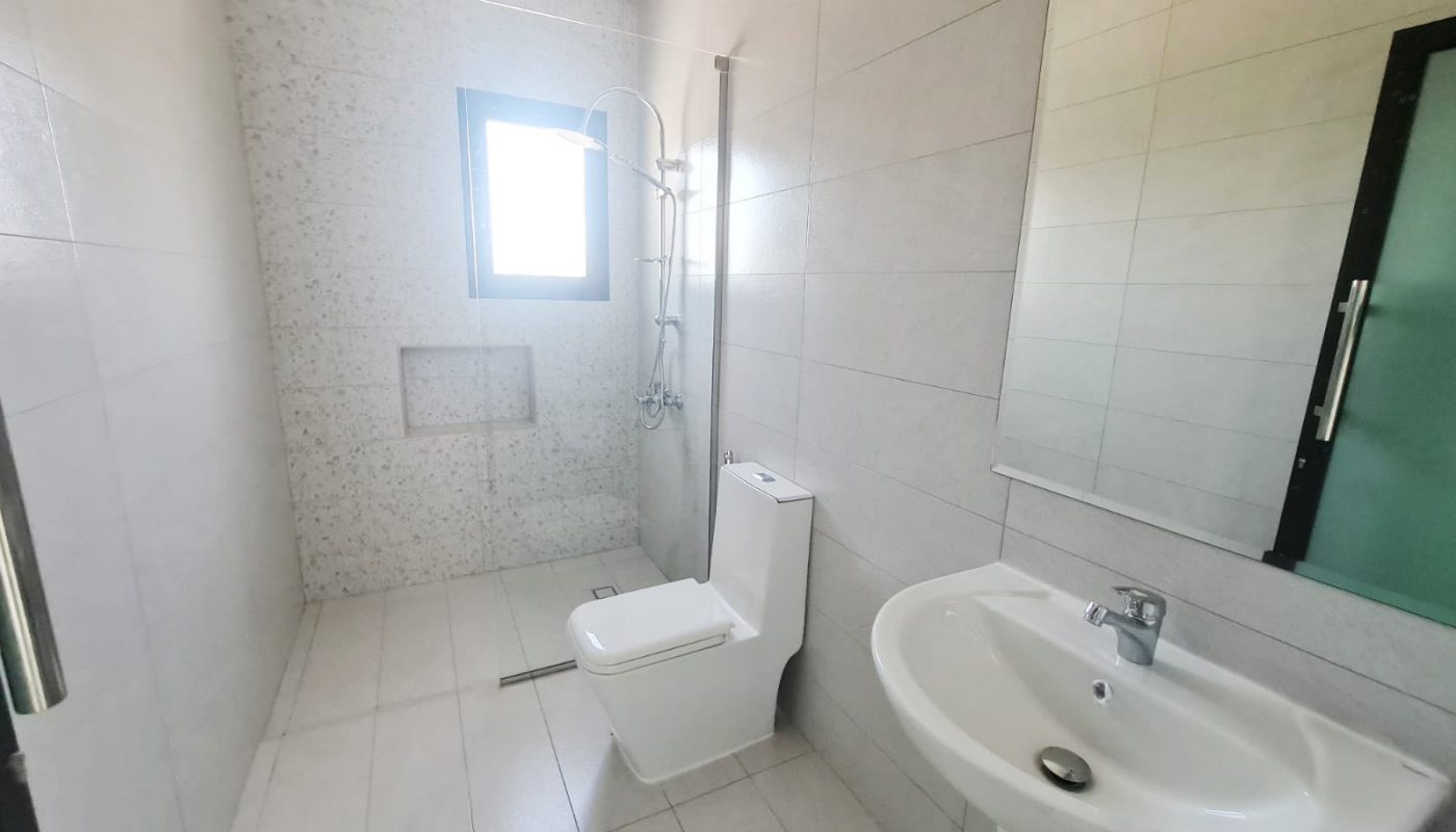 A 4-Bedroom Modern Luxury Villa for Sale in Barbar featuring a bathroom with a toilet, sink, and shower.