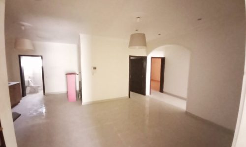 A fish eye view of an empty living room in a building for sale in Juffair.