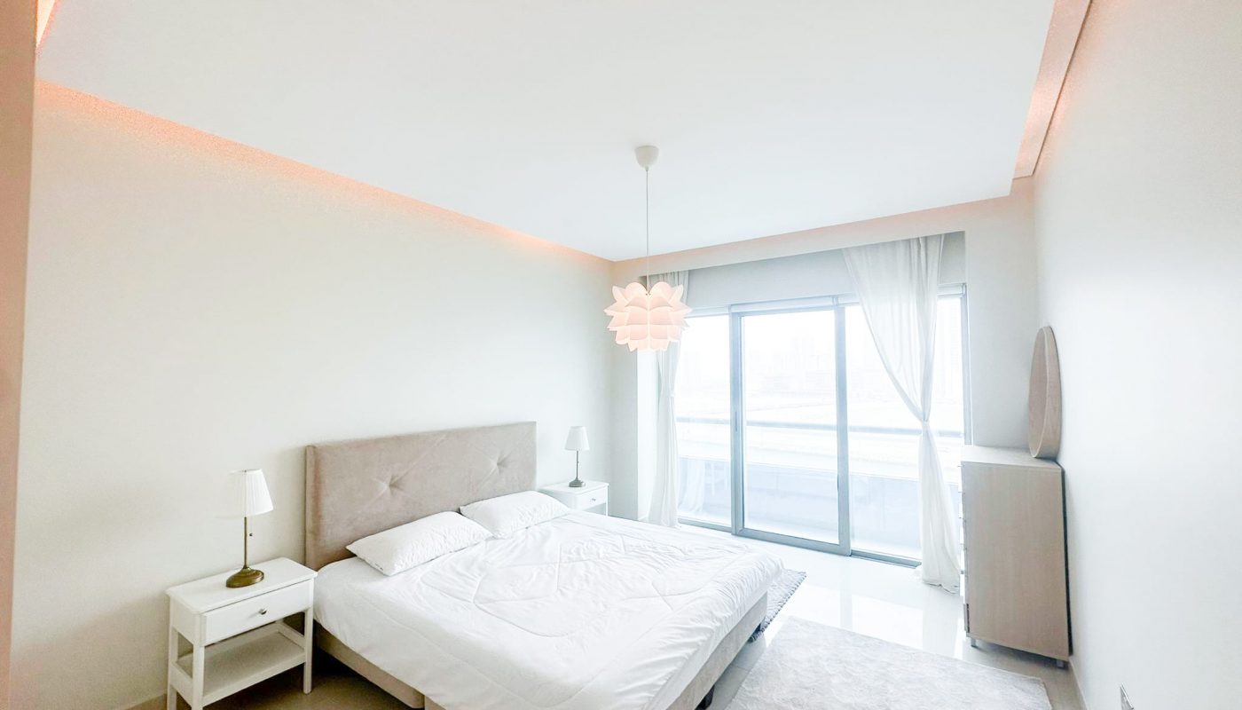 A luxury bedroom with a bed and a large window offering a breathtaking sea view.