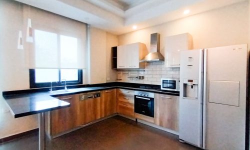 A rent apartment in Adliya with stainless steel appliances and wooden cabinets.