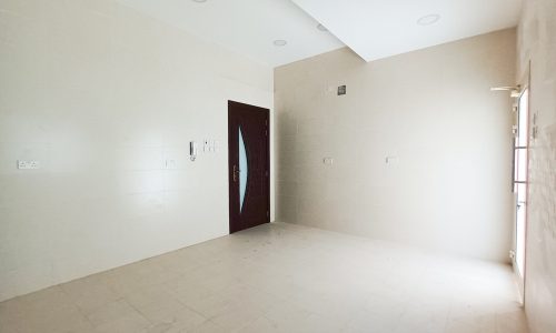 An empty room with white walls and a door for sale.