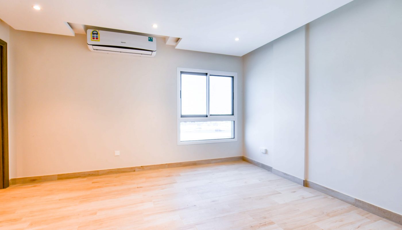 A spacious apartment with wooden floors and a window.