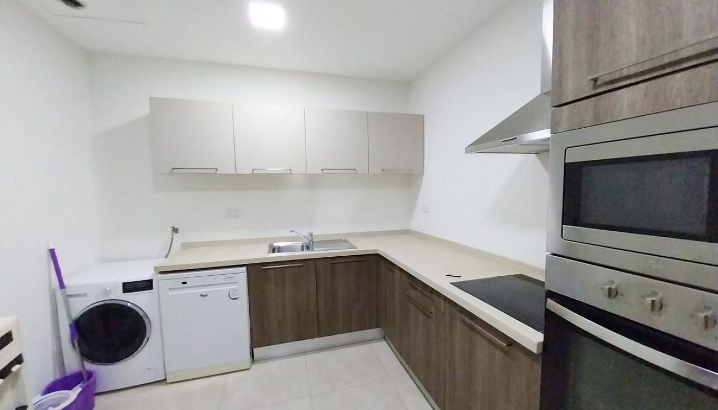 A luxury apartment with a washer and dryer in the kitchen.