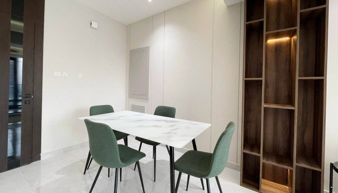A modern dining room with a white table and chairs.