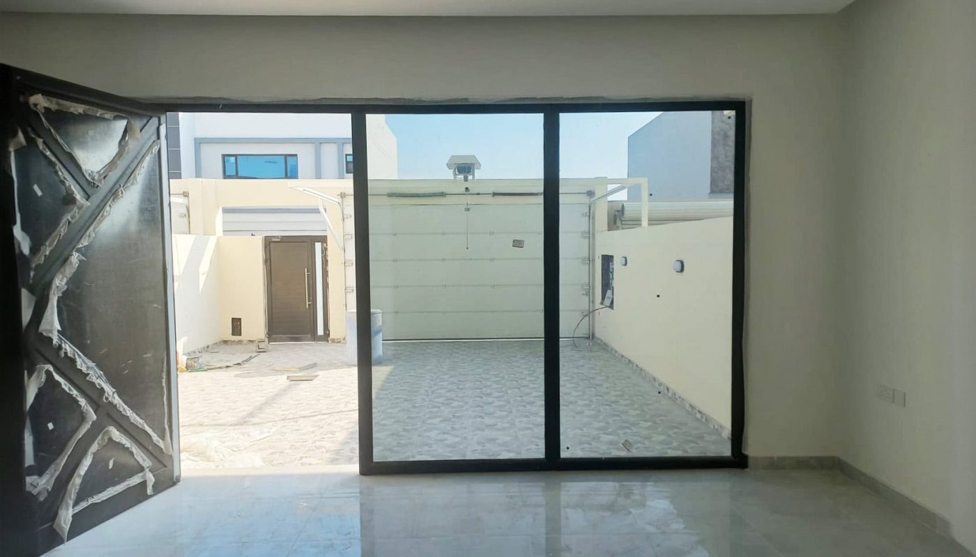 A large empty room in the distinguished villa with sliding glass doors.