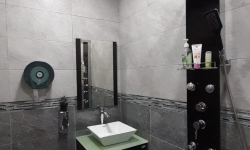 An apartment in Samaheej for sale with a shower, sink, and toilet.
