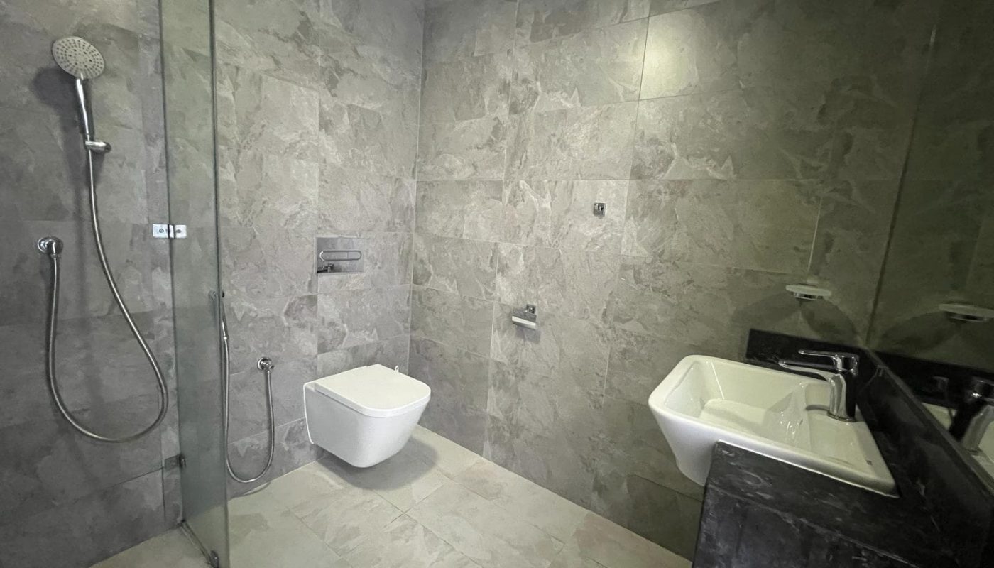 A bathroom with a shower, sink and toilet.